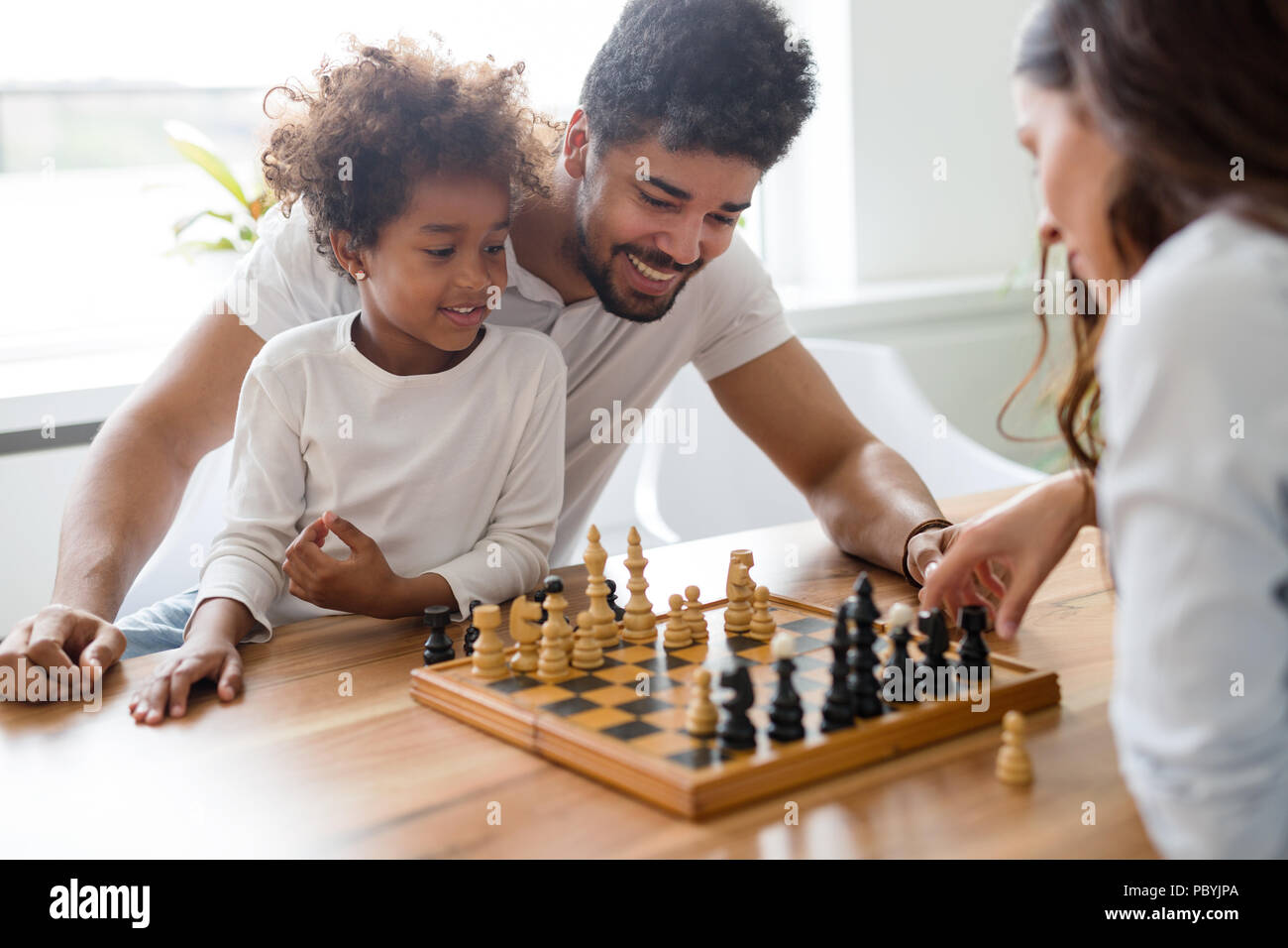 Happy family playing chess together at home Stock Photo - Alamy