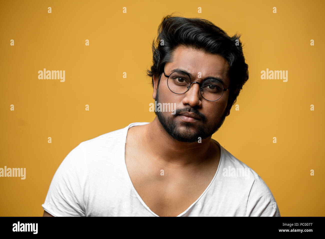 clever pleasant Indian man wearing round glasses and white t-shirt Stock  Photo - Alamy