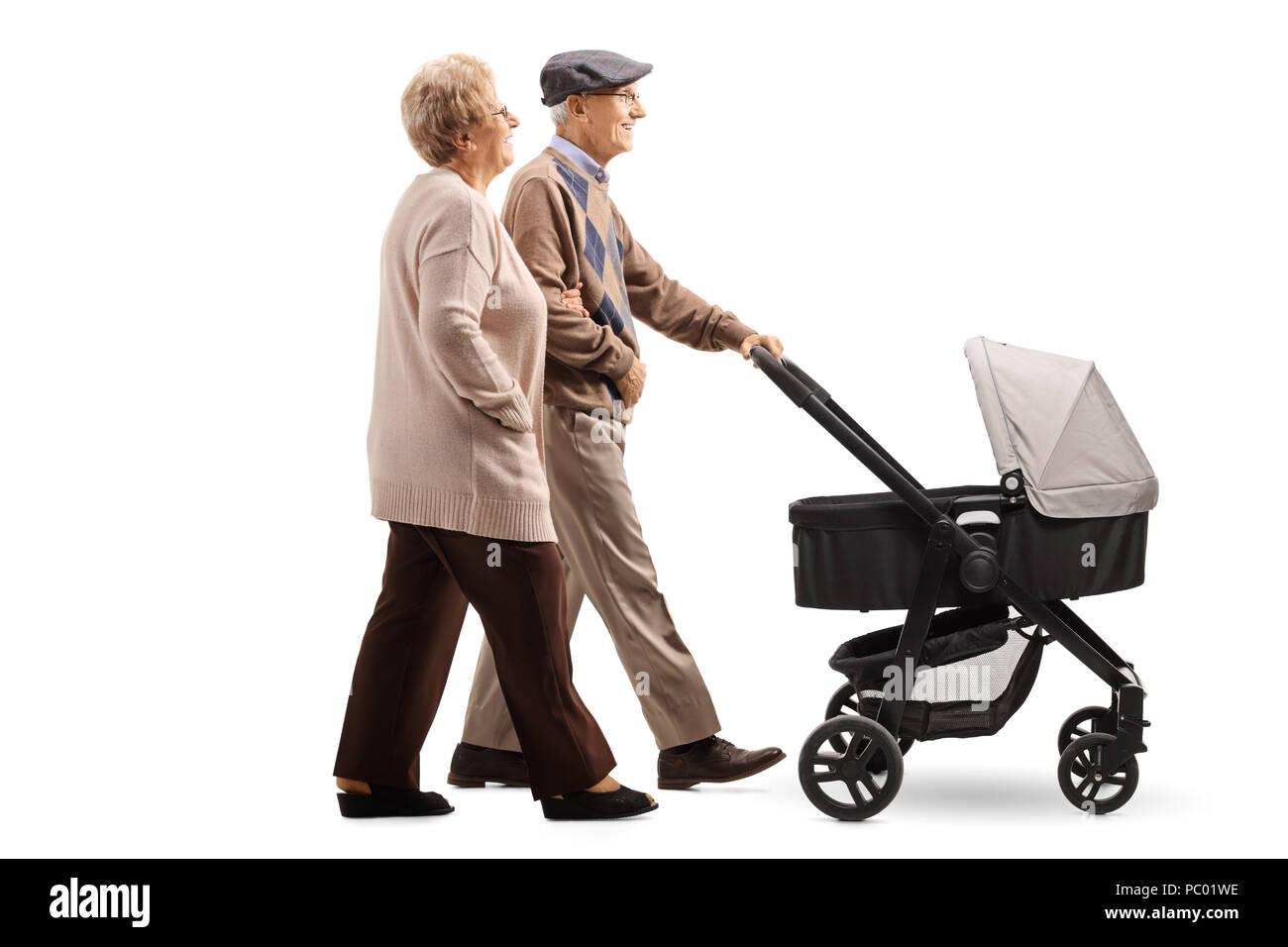 Full length profile shot of a senior couple pushing a baby stroller isolated on white background Stock Photo