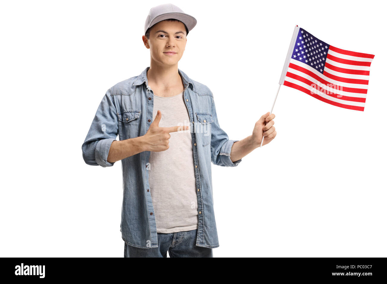Teenage boy holding an American flag and pointing isolated on white ...