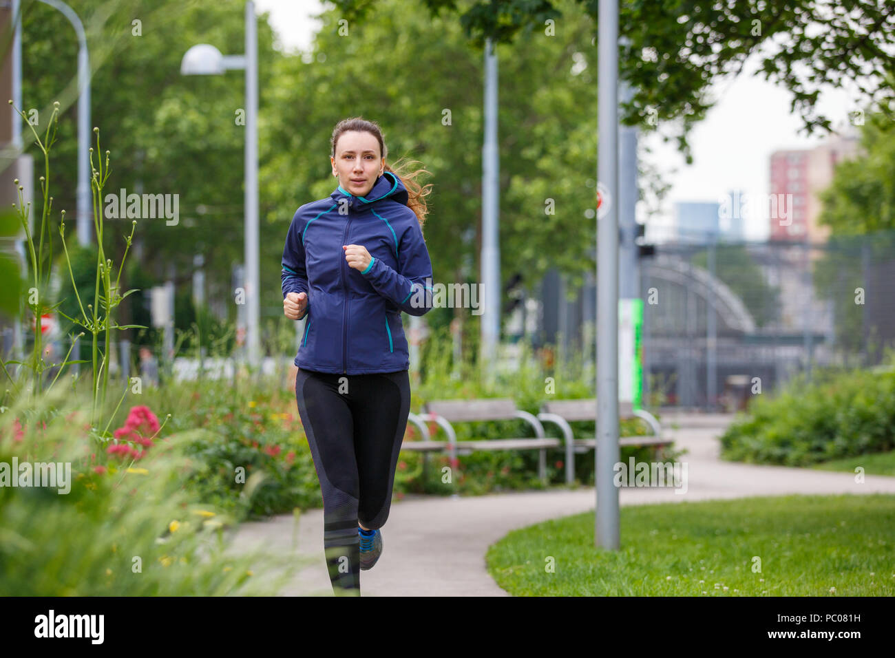 Young woman running in european city park Stock Photo