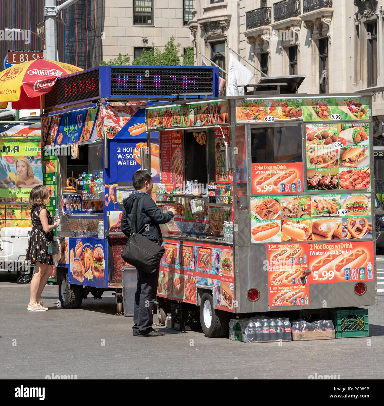 Museum Mile, 5th Avenue, New York, USA. Street food vendors and customers on the sidewalk. Stock Photo