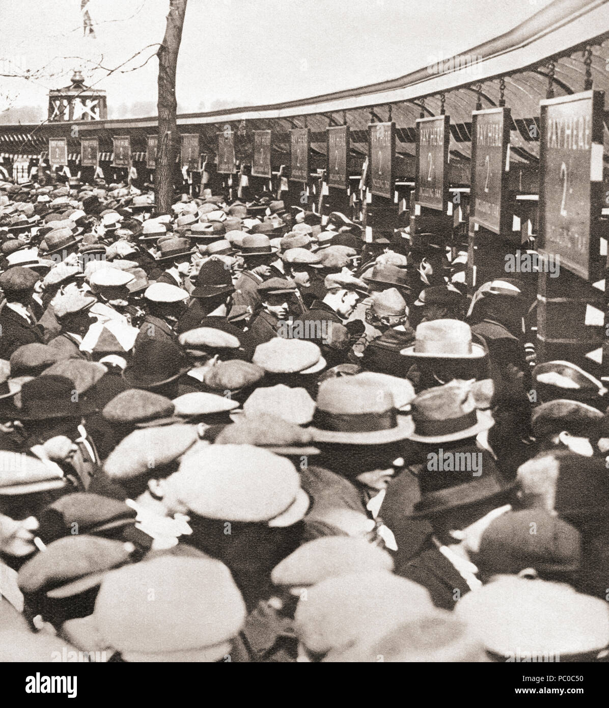 Crowds of people trying to get into Wembley Stadium for the first ever FA Cup Final in 1923 between Bolton Wanderers and West Ham United.  A crowd of around 300,000 got into the stadium which had a capacity of 125,000, many of them had to be cleared off the pitch by a policeman mounted on a white horse, the match is often referred to as the 'White Horse Final'.  From These Tremendous Years, published 1938. Stock Photo