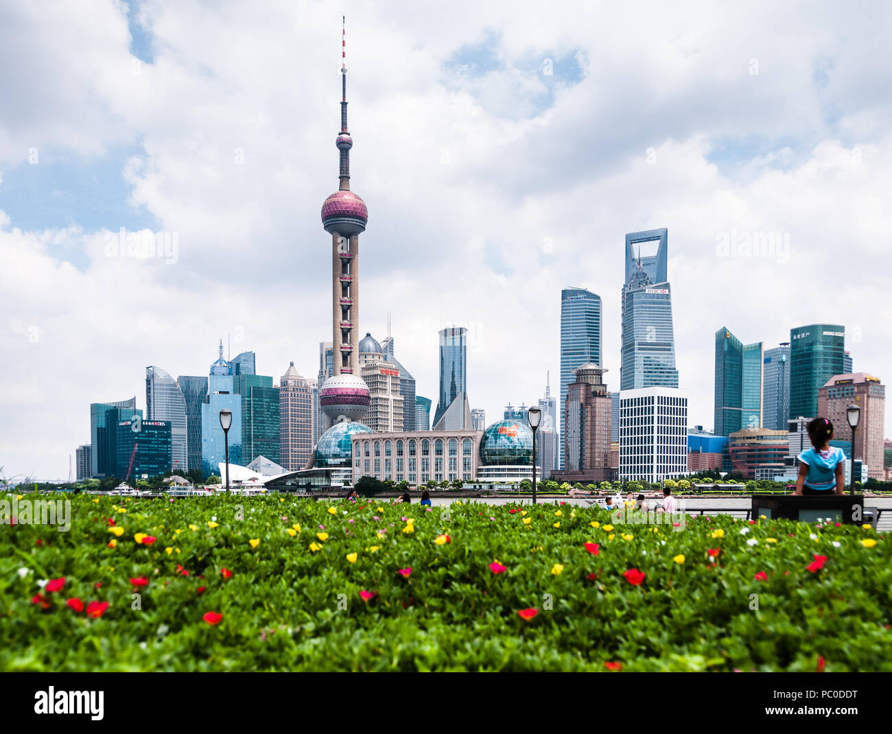 Landscape view of the Bund (Waitan), Shanghai, with yellow and red flowers in the foreground and the Oriental Pearl TV Tower in the background Stock Photo