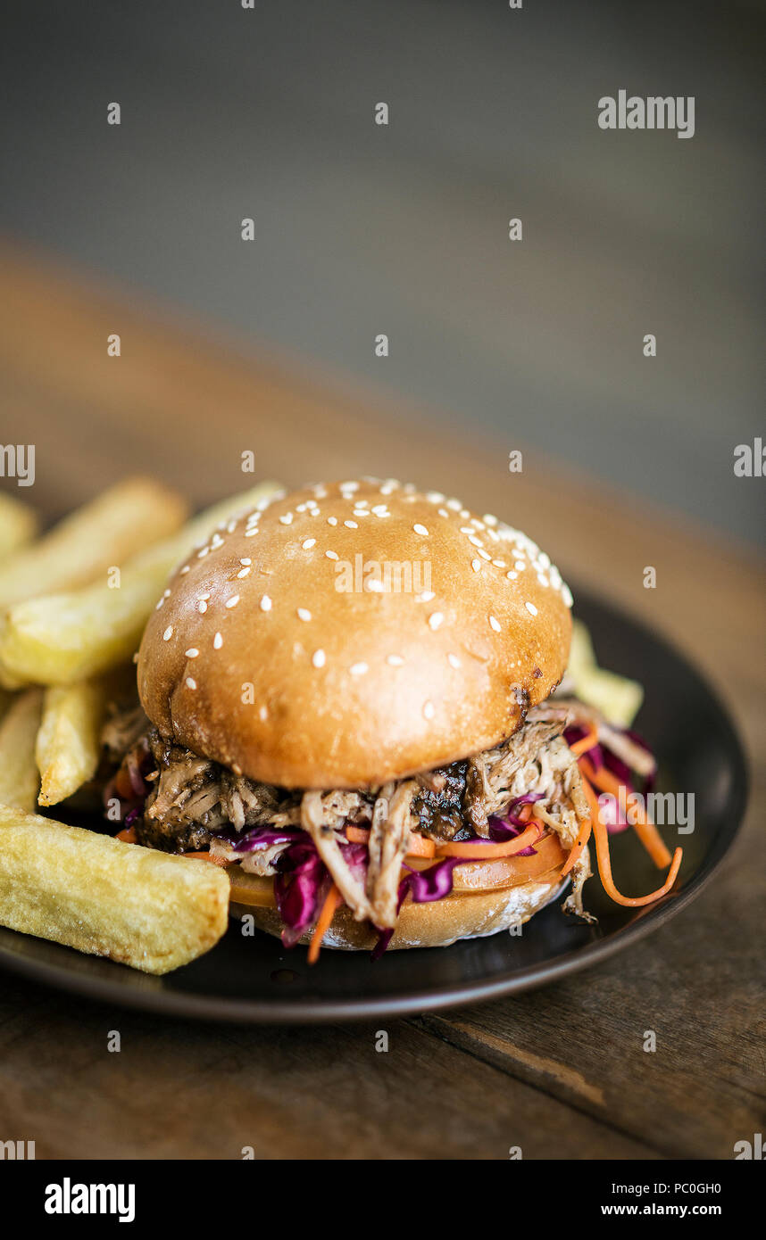pulled pork and coleslaw salad burger sandwich with french fries snack meal Stock Photo
