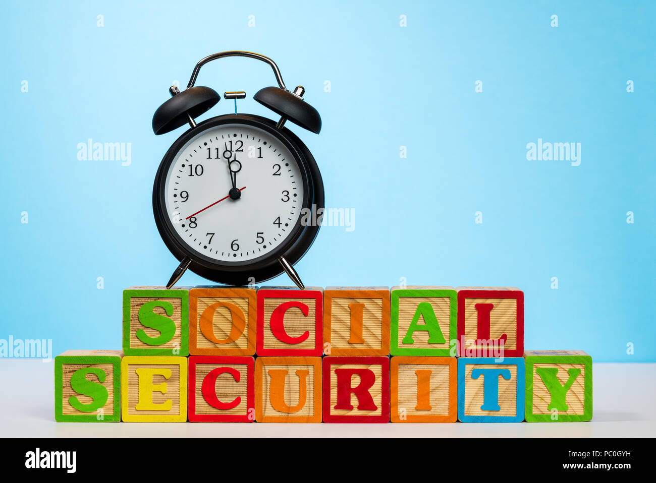 Alarm clock on wooden blocks for Social Security Stock Photo