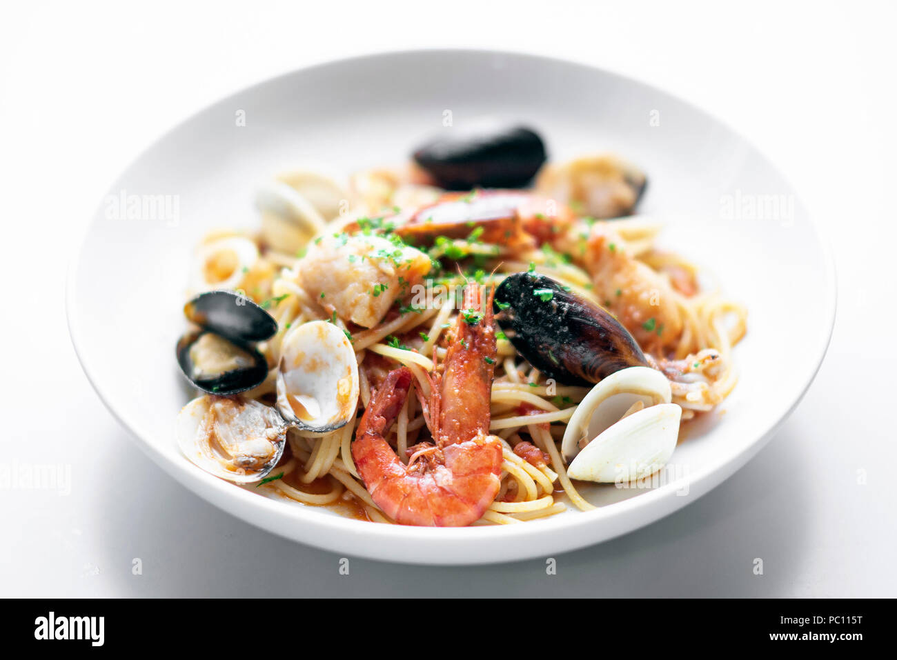 italian mixed fresh seafood spaghetti pasta with prawns mussels scallops and clams Stock Photo