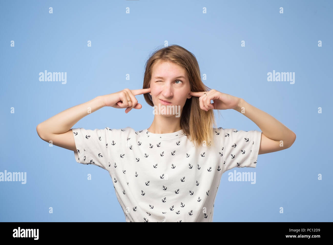Portrait of funny european woman plugging ears, closing her eyes, pretending not to hear wat she is told Stock Photo