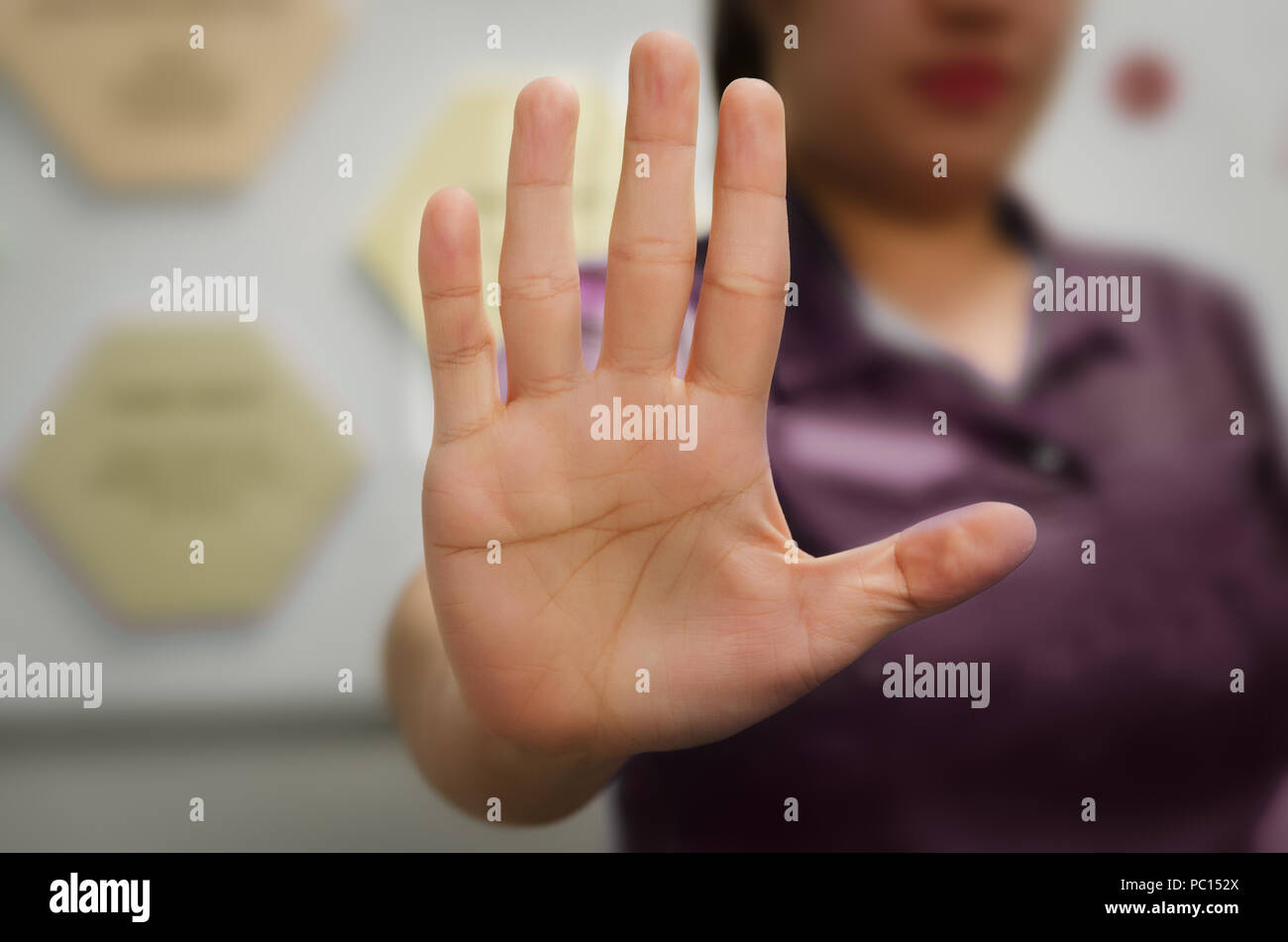 A person showing an open hand signal that means stop or wait isolated on a blurred background Stock Photo