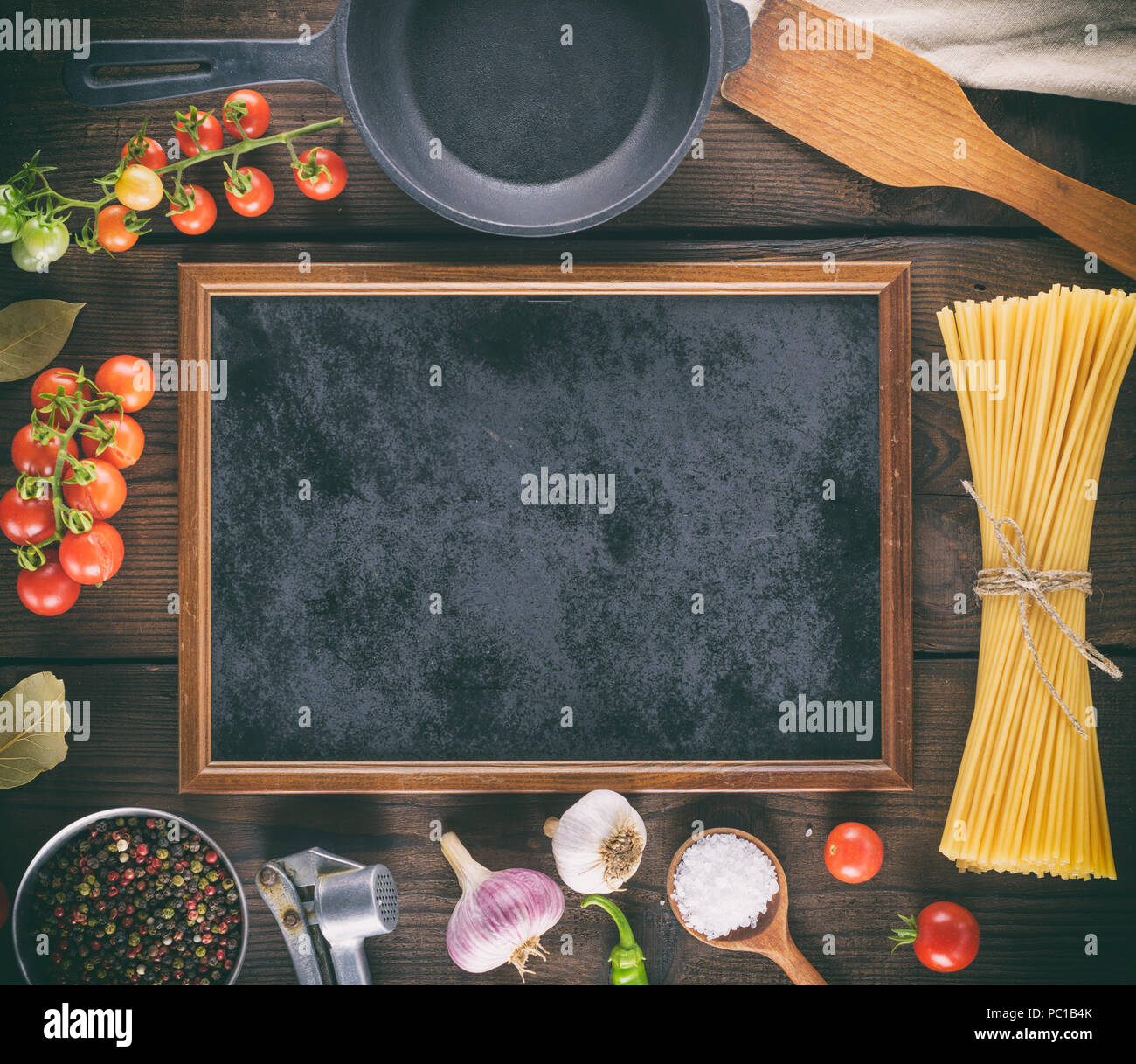 empty black frame and ingredients for pasta cooking on a wooden background, top view Stock Photo