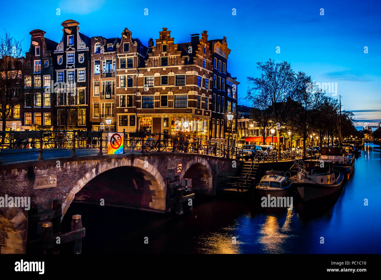 Night view with bridge, bicycles and water reflection in Amsterdam city, Netherlands Stock Photo