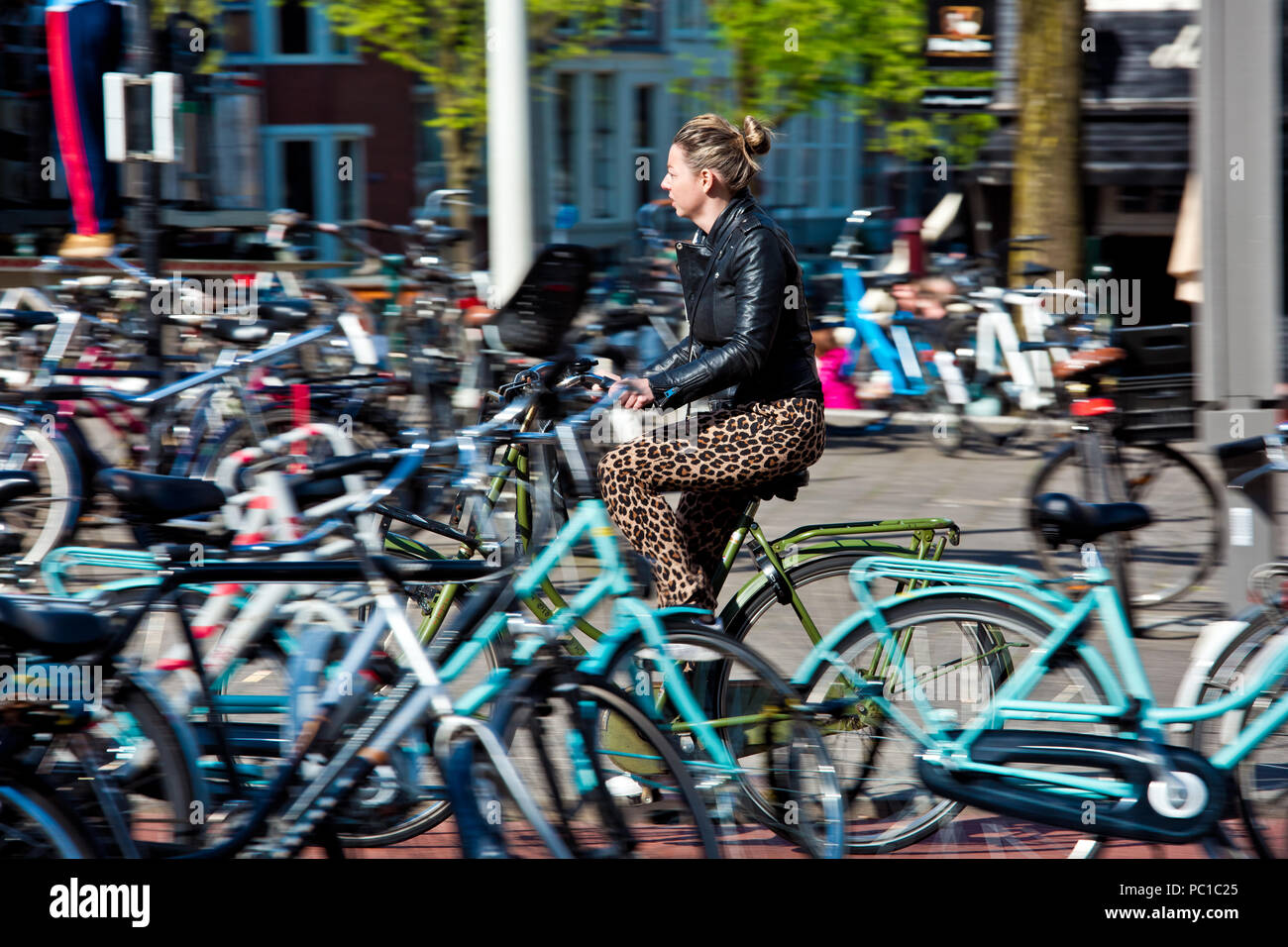 Amsterdam, Netherlands - April, 2018: Cyclist girl on Amsterdam street in Netherlands Stock Photo