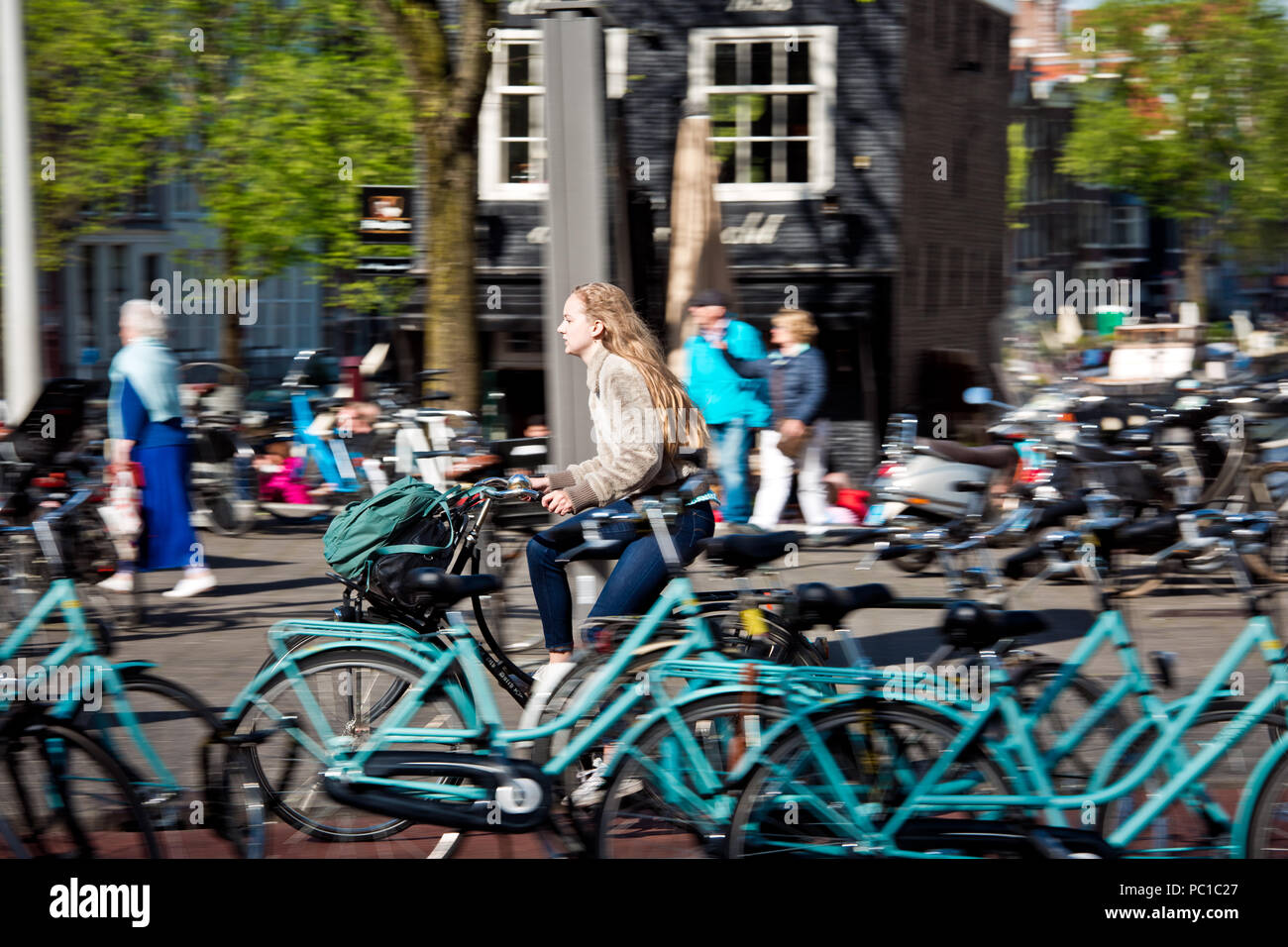Amsterdam, Netherlands - April, 2018: Cyclist girl on Amsterdam street in Netherlands Stock Photo