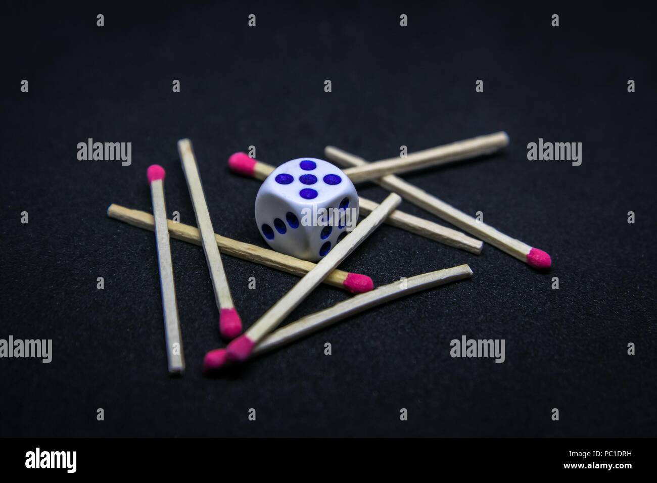 Cube surrounded by matches on a bunch. Don't fire the Fire of Gambling addiction - concept. Stock Photo