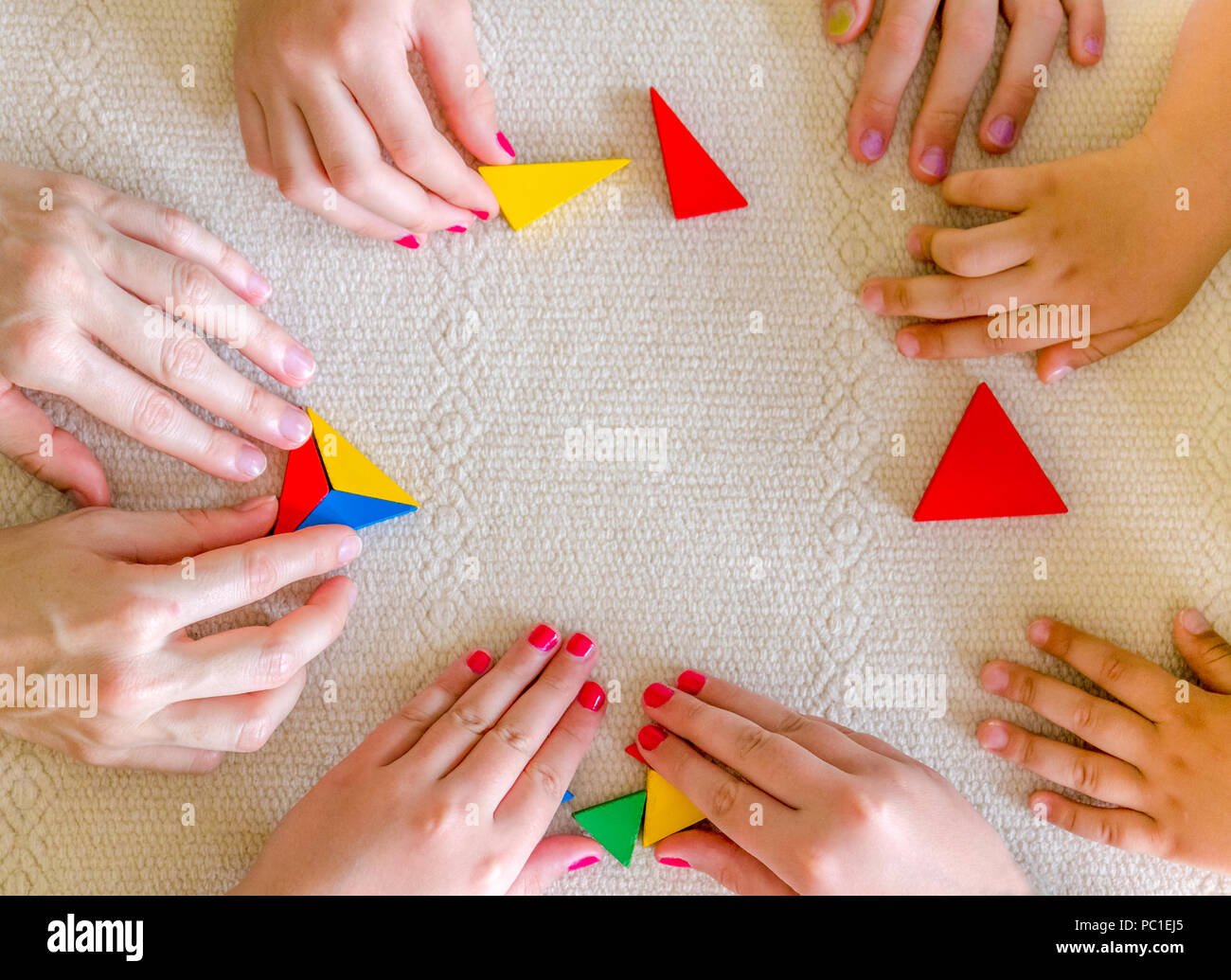 Children and Teacher playing Tangram together. Stock Photo