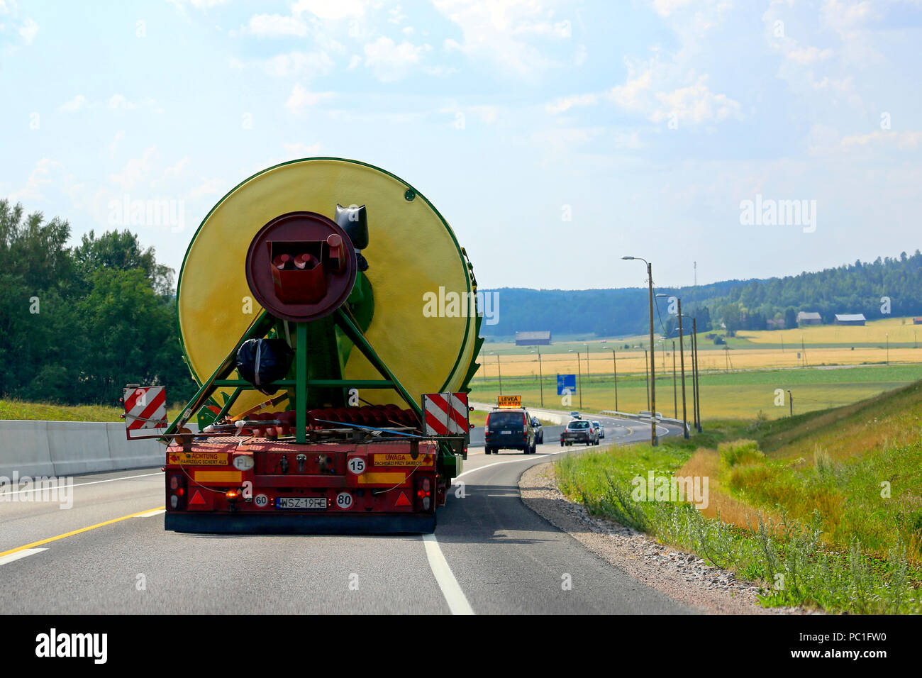 Rear view of oversize load transport by semi trailer of Peter-Star, Poland on Highway 52, led by pilot vehicle. Salo, Finland - July 27, 2018. Stock Photo