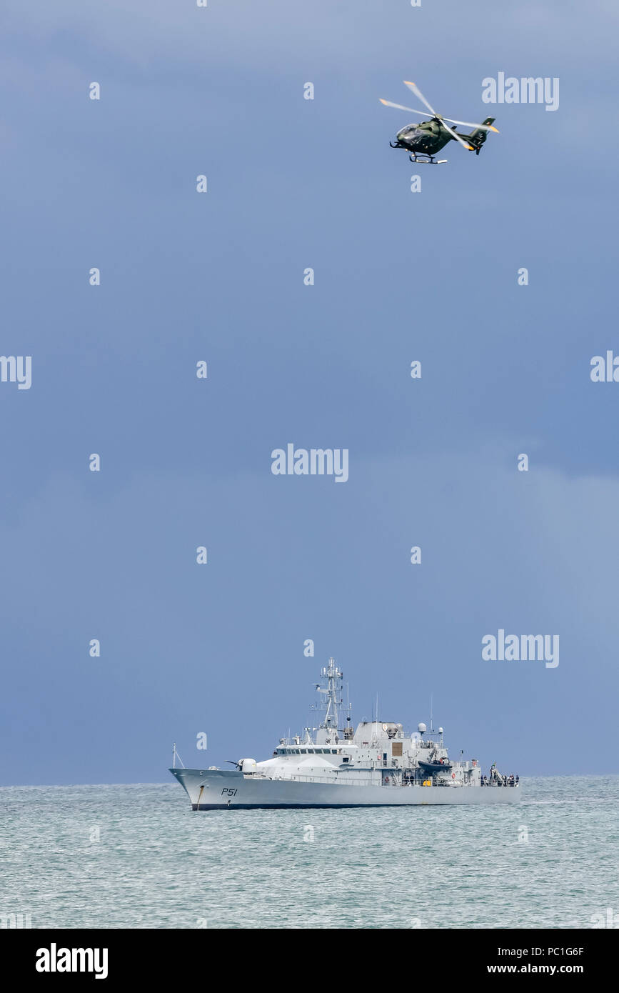 Eurocopter EC-135 training helicopter belonging to the Irish Air Corps flies over LÉ Róisín (P51) offshore patrol ship for the Irish Naval Service. Stock Photo