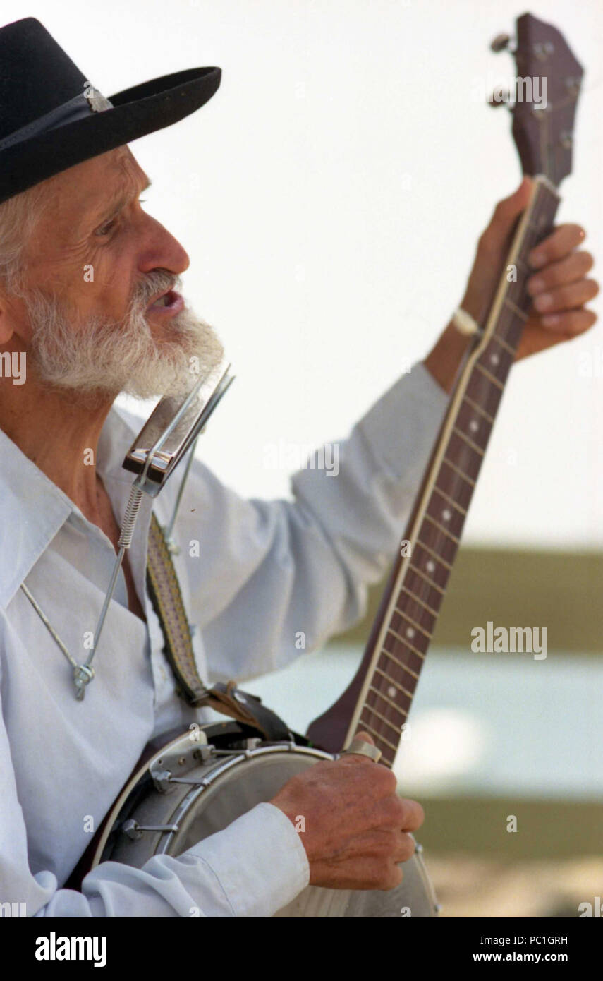 Man performing on the street, with banjo and harmonica Stock Photo