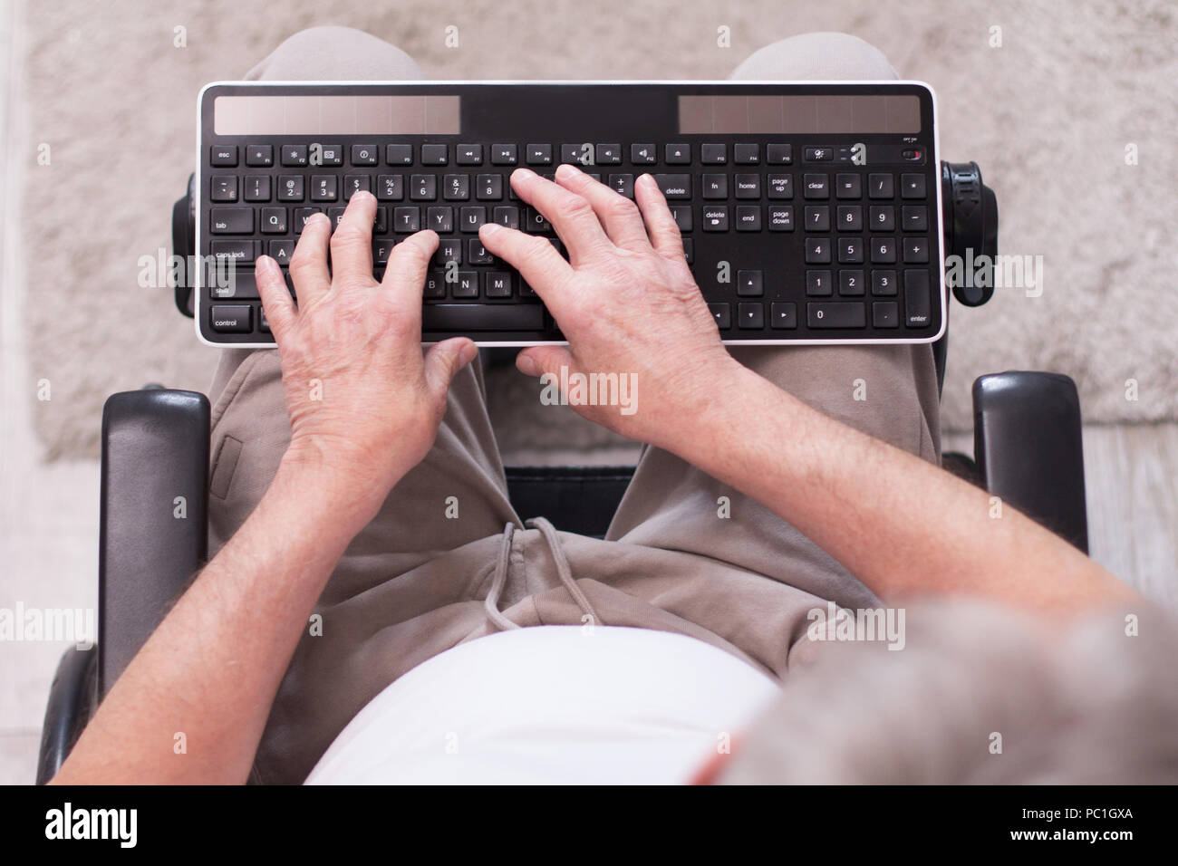 Disabled man typing on keyboard Stock Photo Alamy