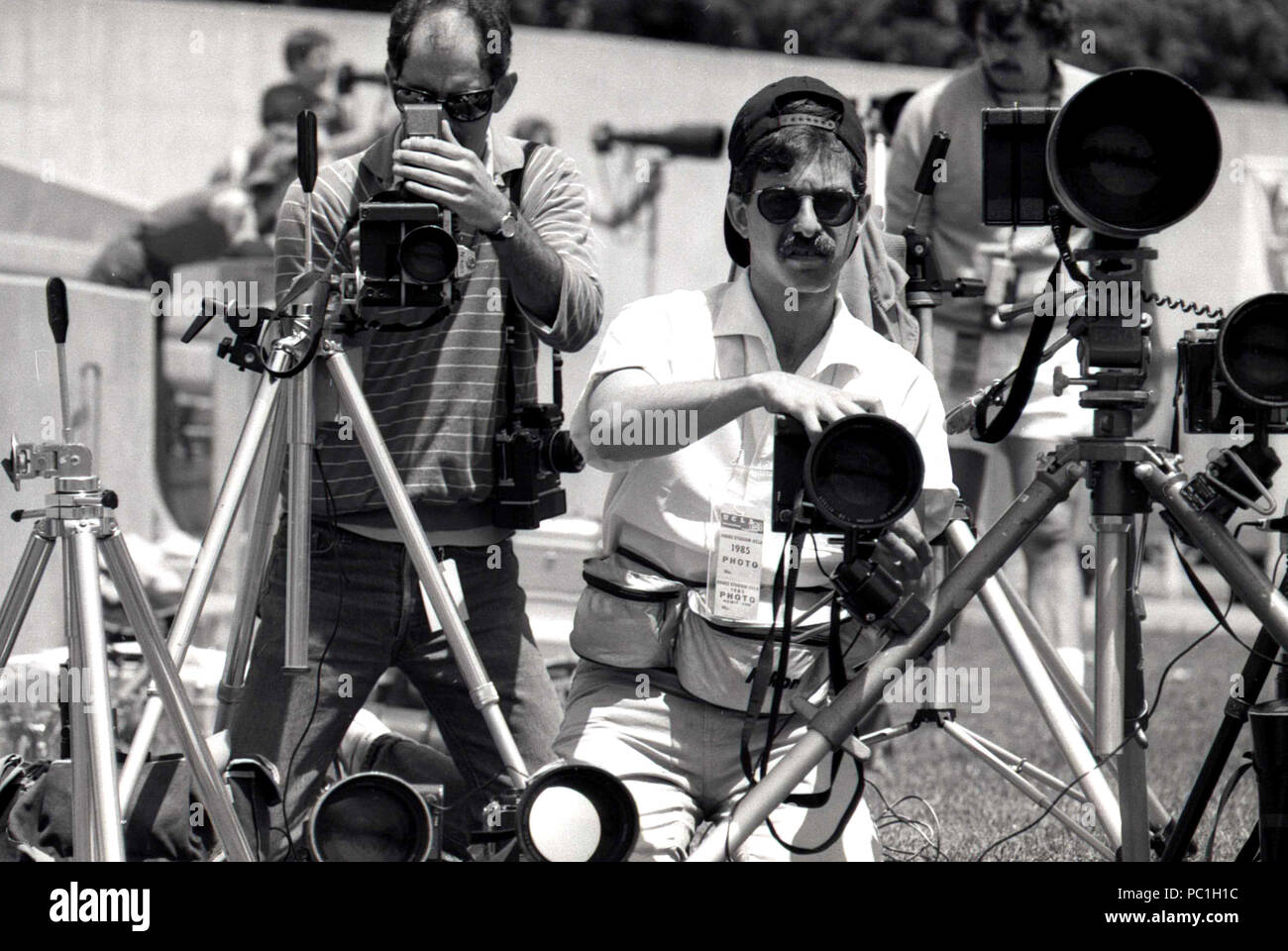 Photojournalists setting up their cameras during sports event, 1990s Stock Photo