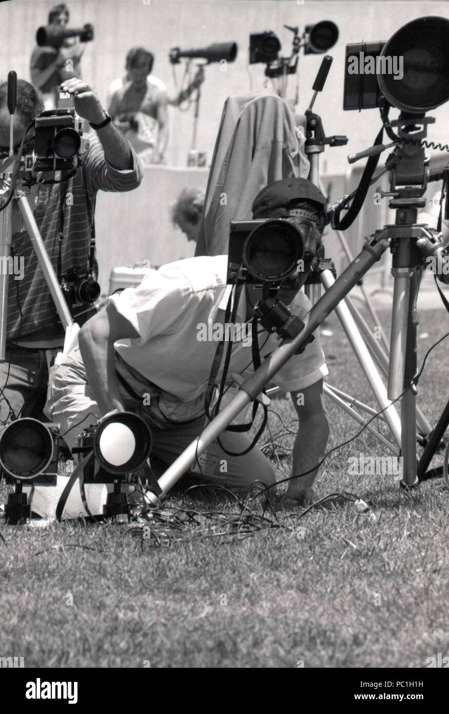 Photojournalists setting up their cameras during sports event, 1990s Stock Photo
