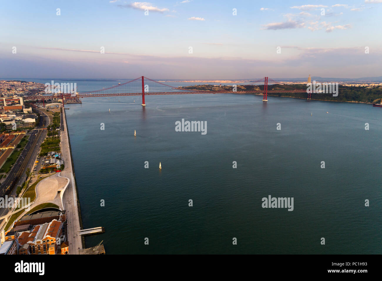 Aerial view of the Tagus River (RIo Tejo) in the city of Lisbon with sail boats and the 25 of April Bridge on the background; Concept for travel in Po Stock Photo