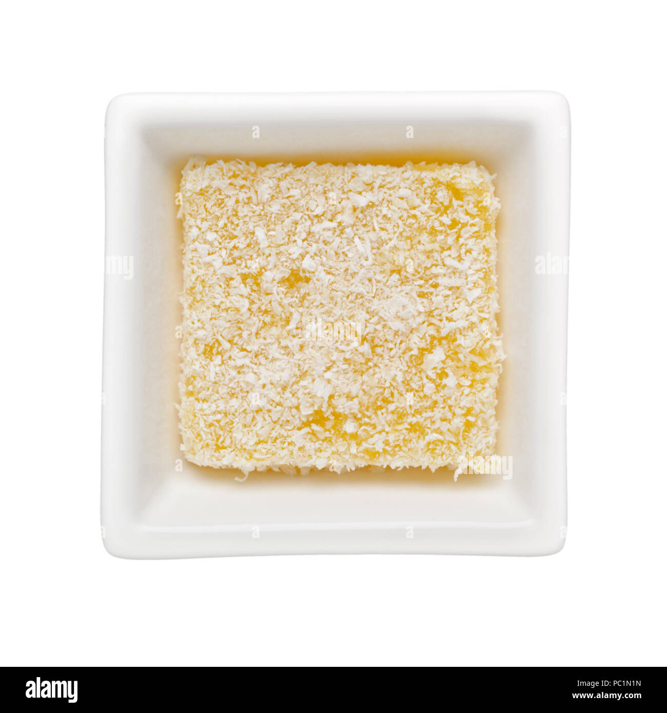 Traditional Kueh Sago covered with coconut shreds in a square bowl isolated on white background; Stock Photo