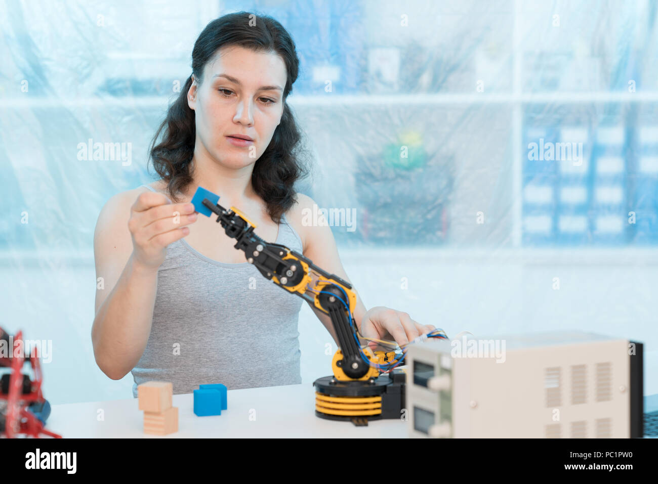 girl in a University laboratory is experimenting with a robot Stock Photo