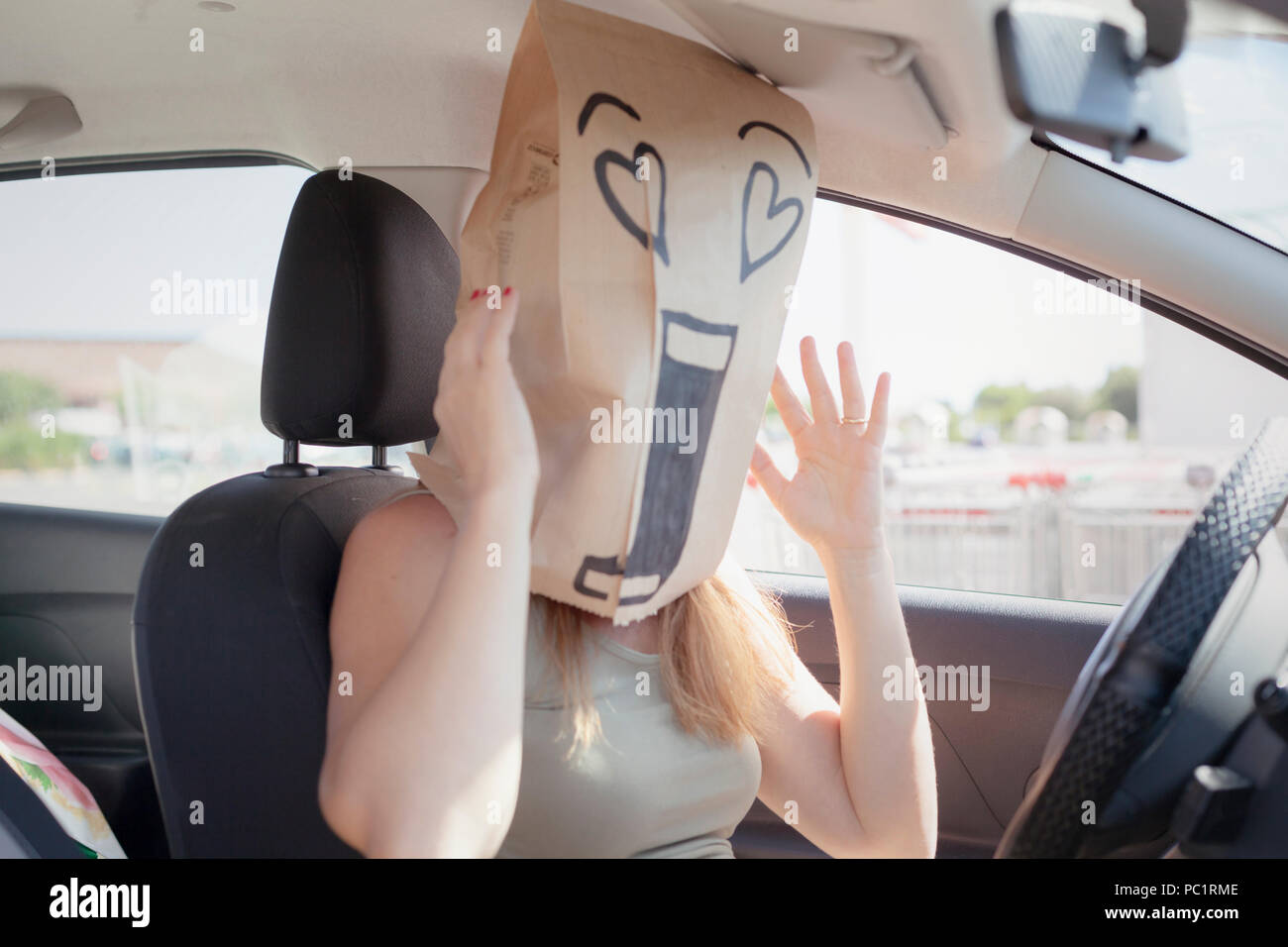 A breadbag face in a car, with a loving incredulous expression. Stock Photo