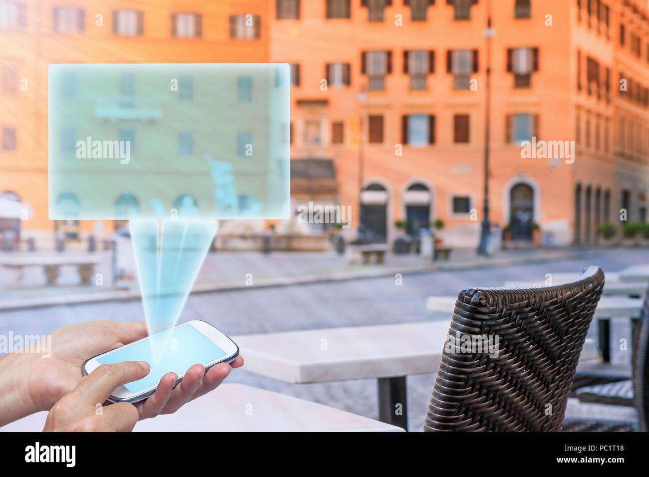 Travel concept of hand holding smart phone with empty transparent rectangle ready for your text. All on empty restaurant tables in sunlight on Navona  Stock Photo