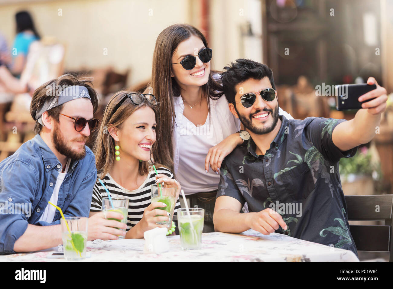 Multiracial group of best friends taking selfie at the cafe Stock Photo