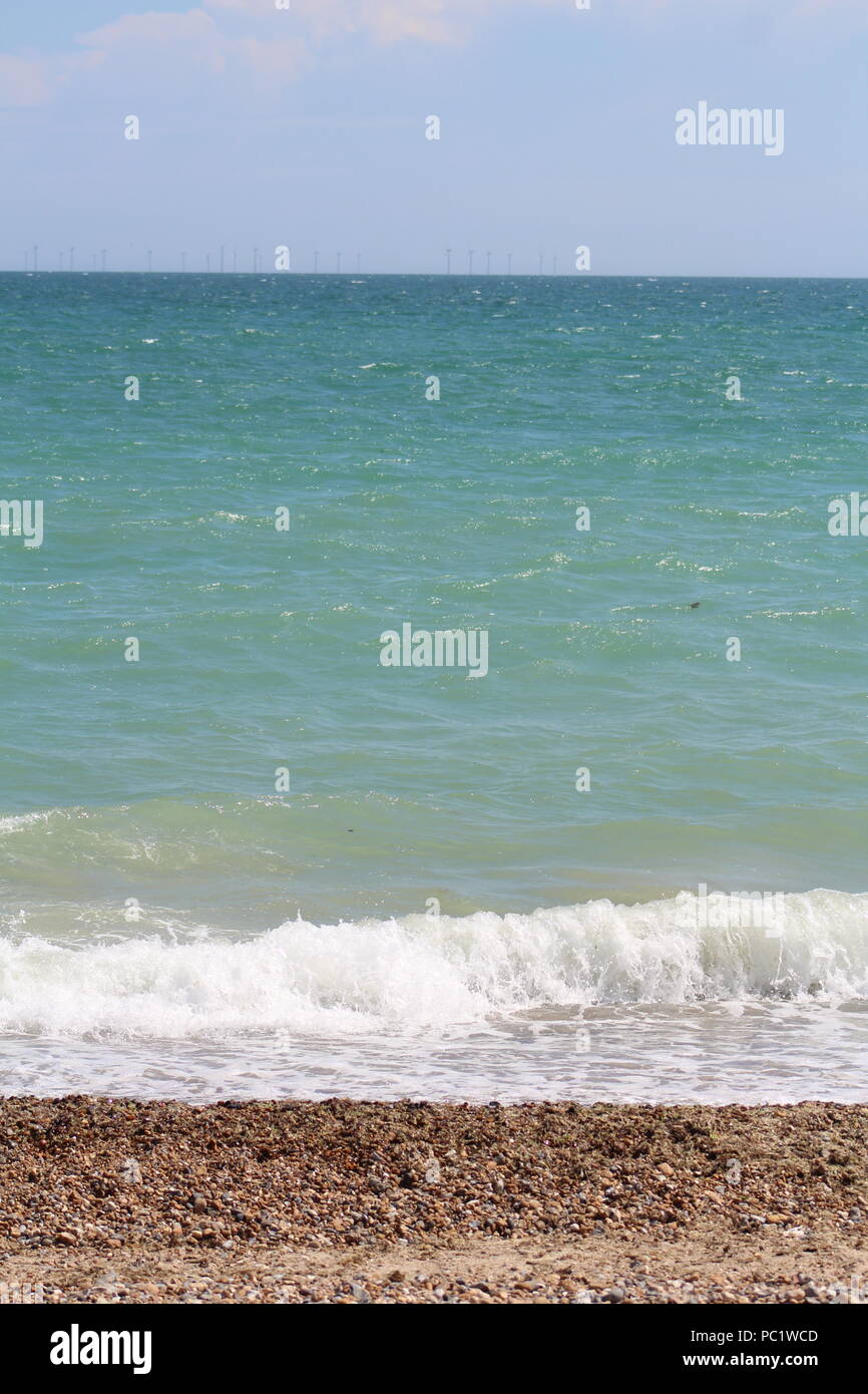 Tide coming in over pebbled beach in Goringbysea Stock Photo Alamy