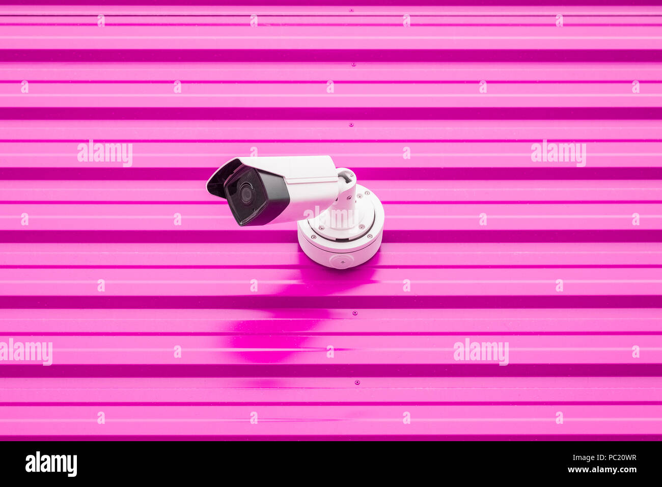 Security camera on pink wall minimal creative concept. Stock Photo