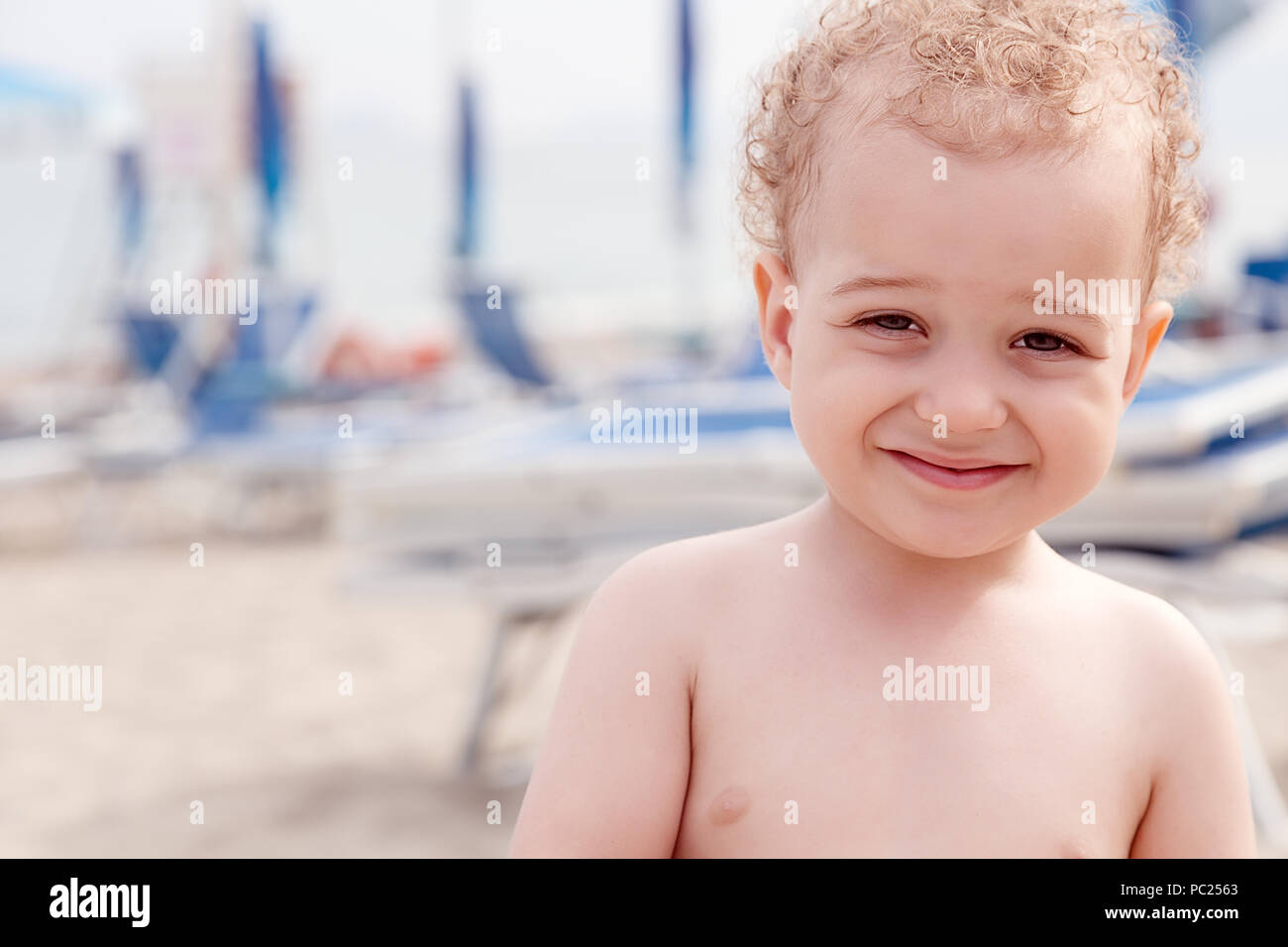 Portrait two years old boy on the beach and the sea background. Summer