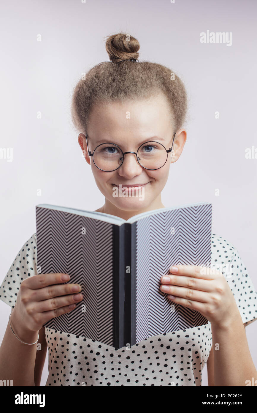 close up portrait of smiling young female holding a book. young teacher ...