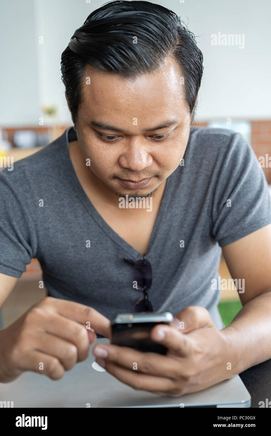 young man using smartphone in a cafe Stock Photo