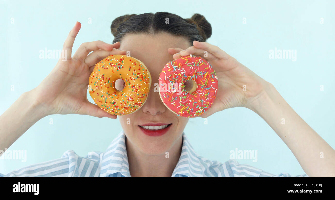 Woman is taking donuts and makes sunglasses from it Stock Photo