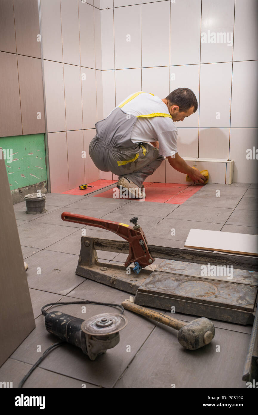 Tile Contractor Install ceramic tiles in bathroom Stock Photo - Alamy
