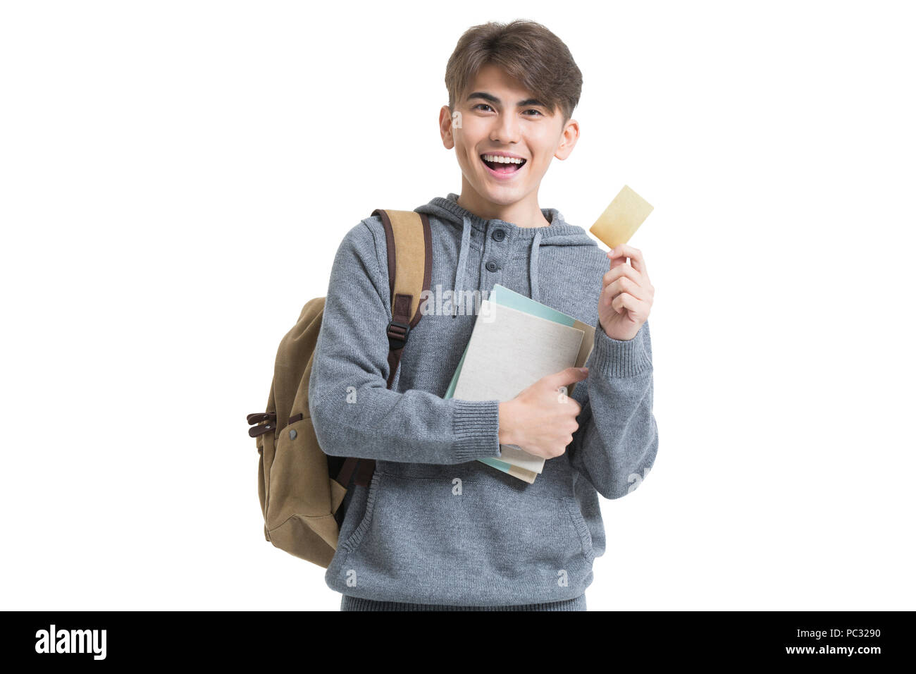 Cheerful male college student holding books and credit card Stock Photo