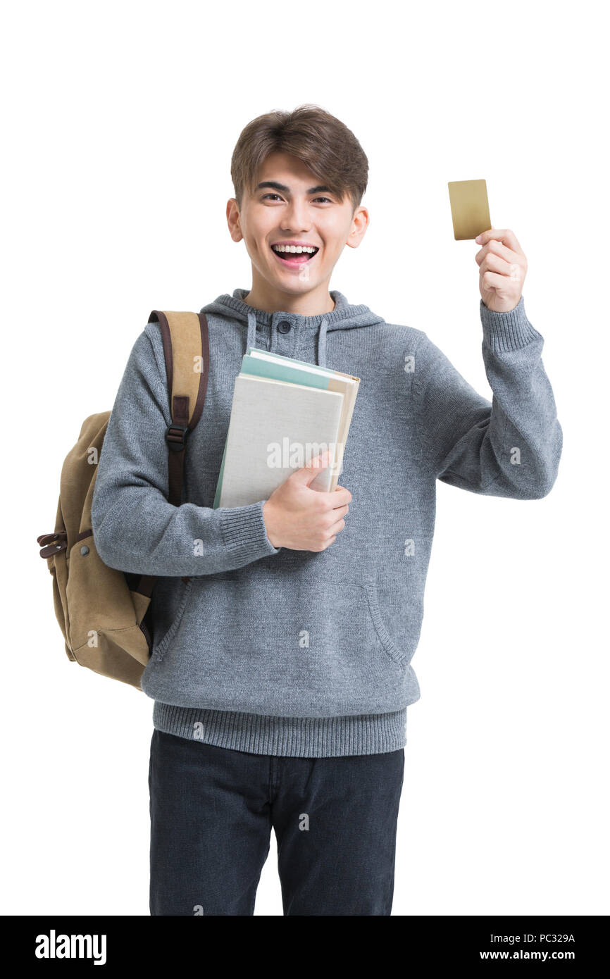 Cheerful male college student holding books and credit card Stock Photo