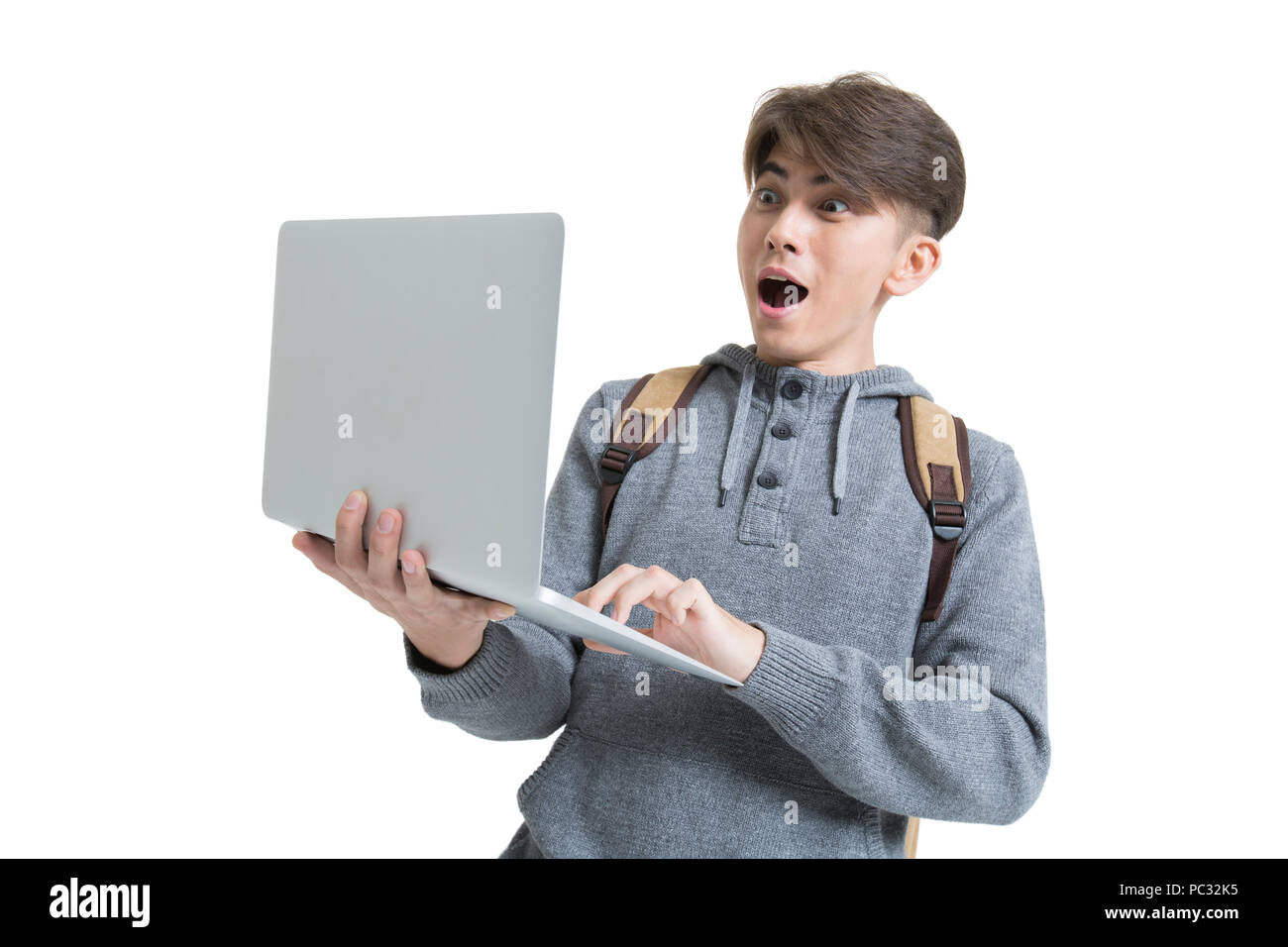 Shocked male college student using laptop Stock Photo