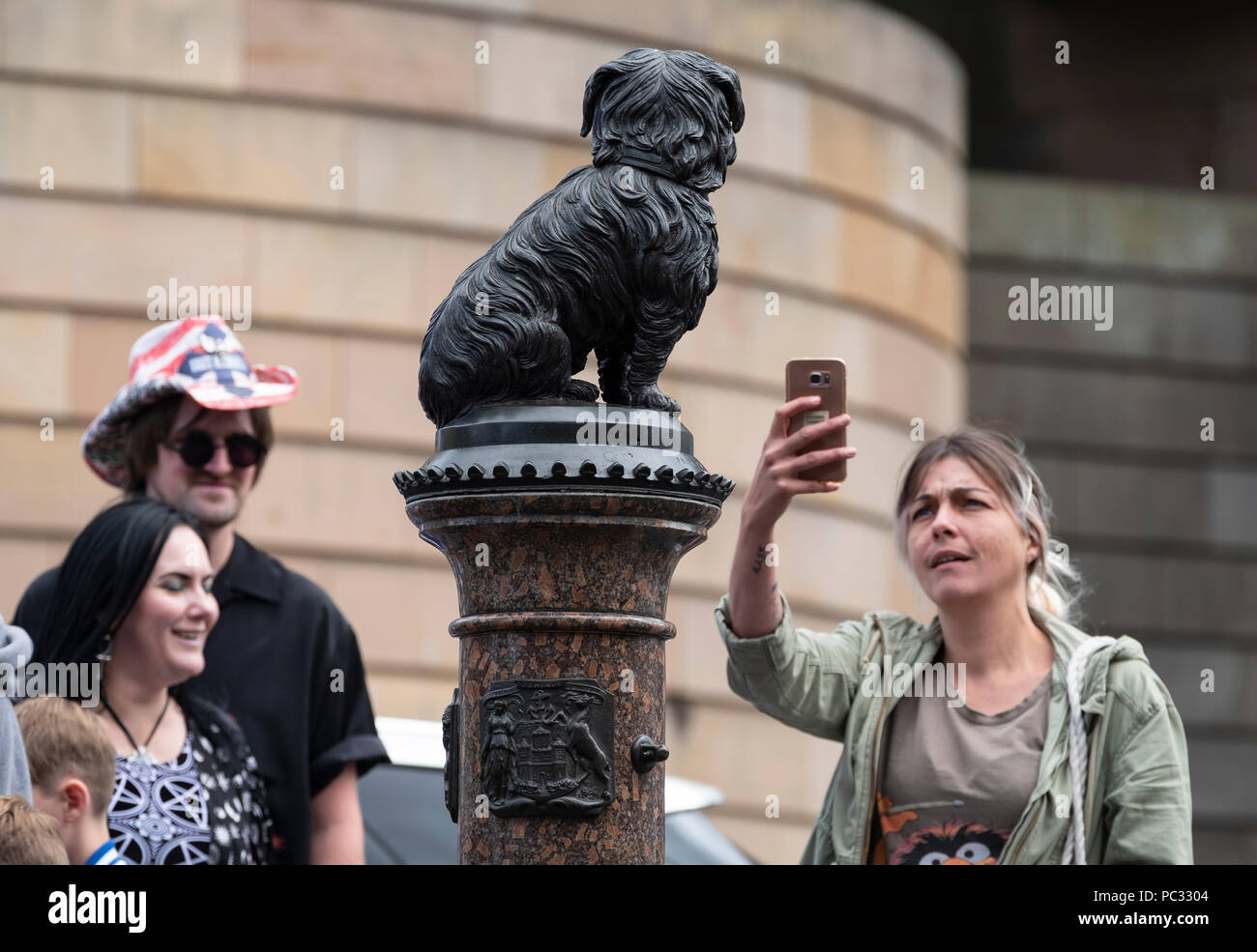 Tourists photograph statue of Greyfriars Bobby in old Town of Edinburgh, Scotland, UK Stock Photo