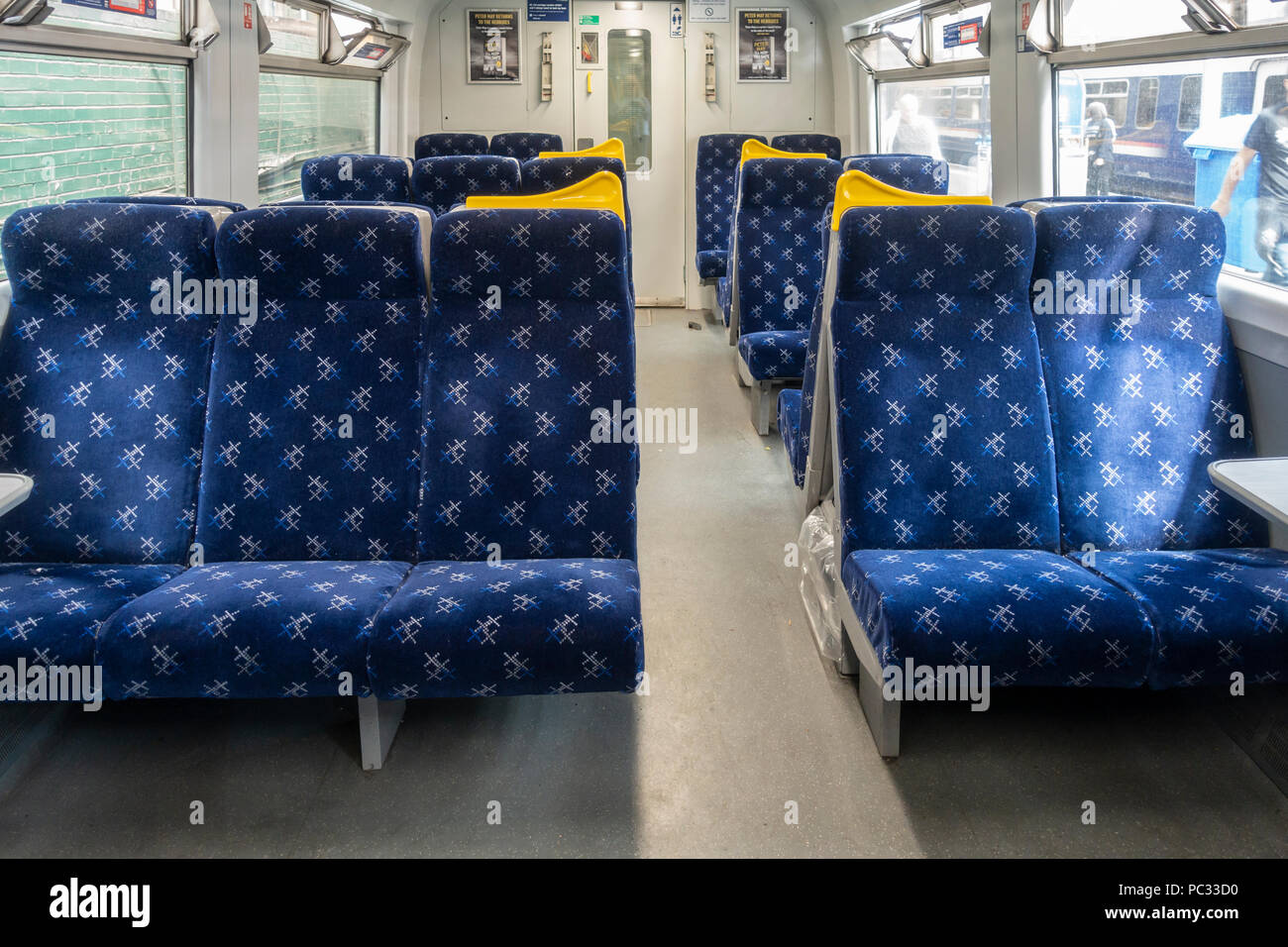 Interior of a Scotrail train carriage while stationary at Glasgow Central station, with passengers and another train seen outside the windows. Stock Photo