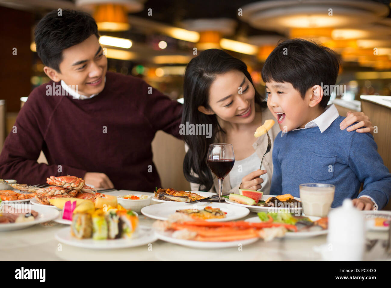 Cheerful young Chinese family having buffet dinner Stock Photo
