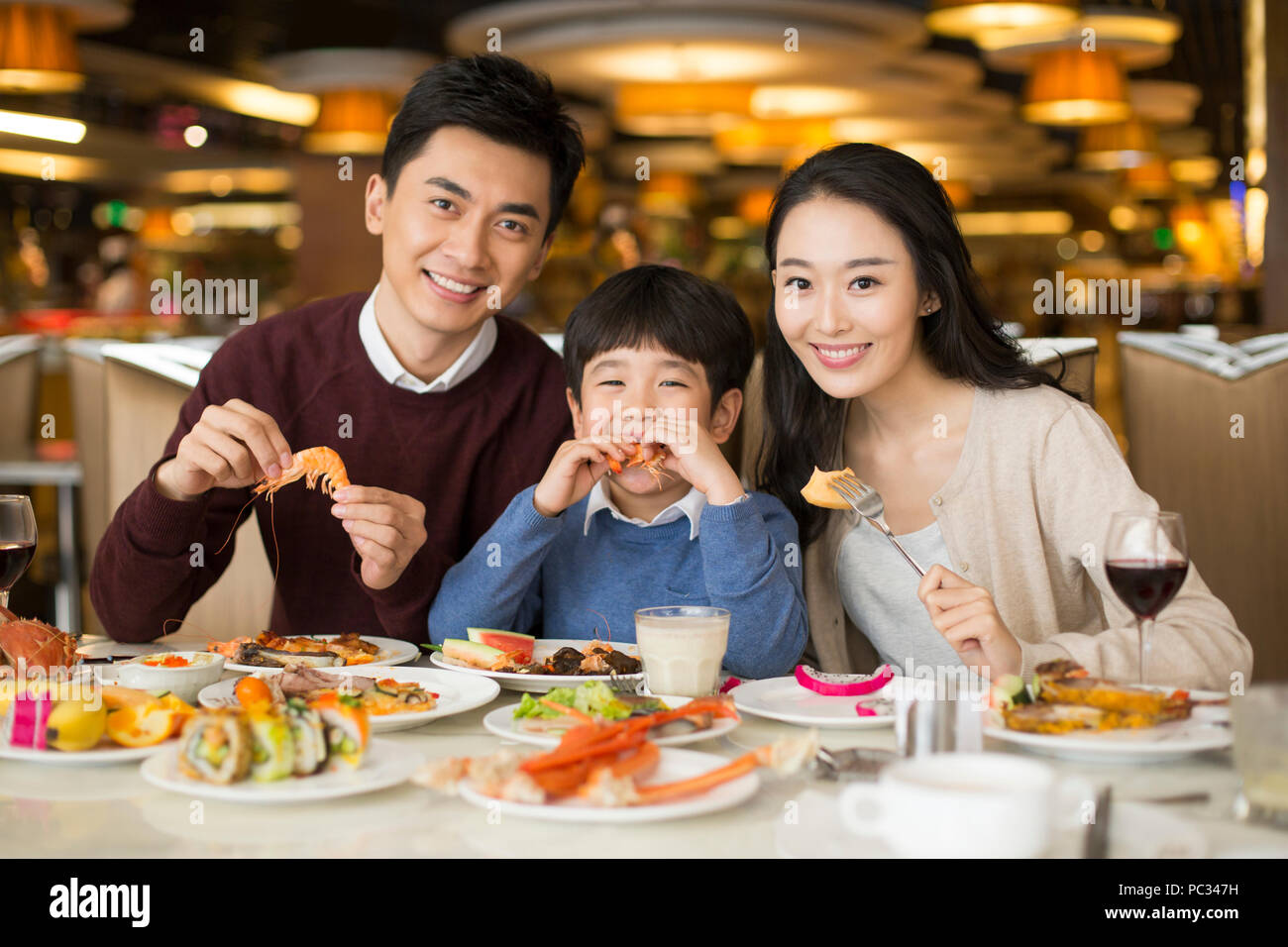 Cheerful young Chinese family having buffet dinner Stock Photo - Alamy