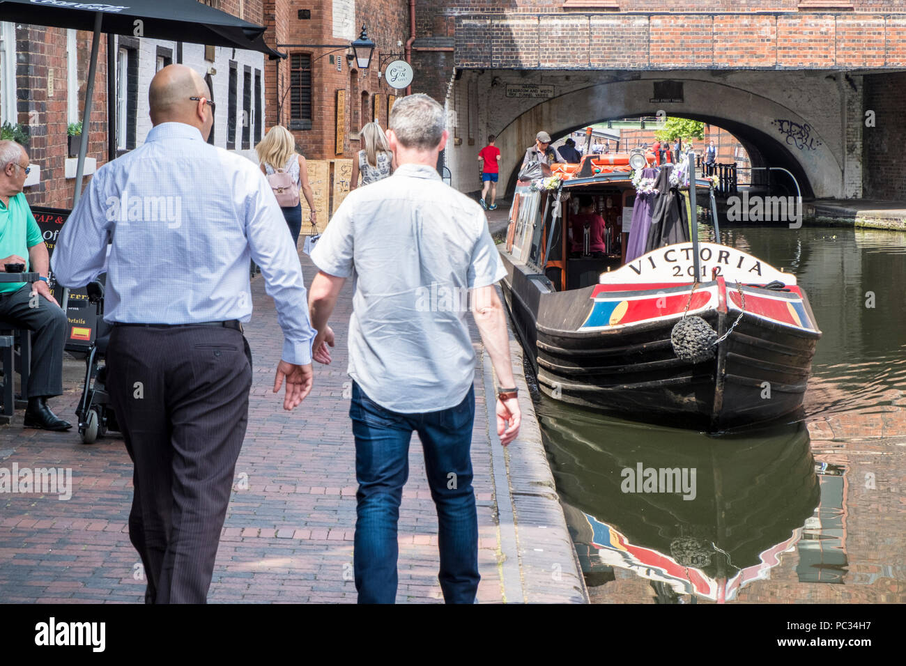 City canals. People on the Birmingham City Centre Path, originally a towpath. Birmingham New Mainline Canal at Broad Street Tunnel, Birmingham, UK Stock Photo
