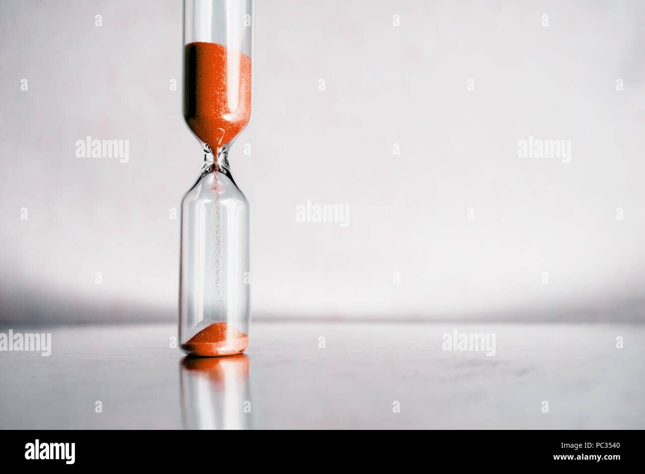 Modern beautiful hourglass with bright background for copy space. Hourglass time passing concept for business deadline, urgency and running out of time. Stock Photo