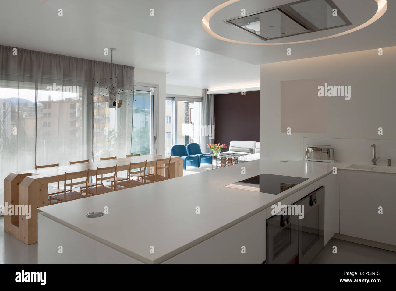 Luxury apartment, modern kitchen and wooden dining table Stock Photo