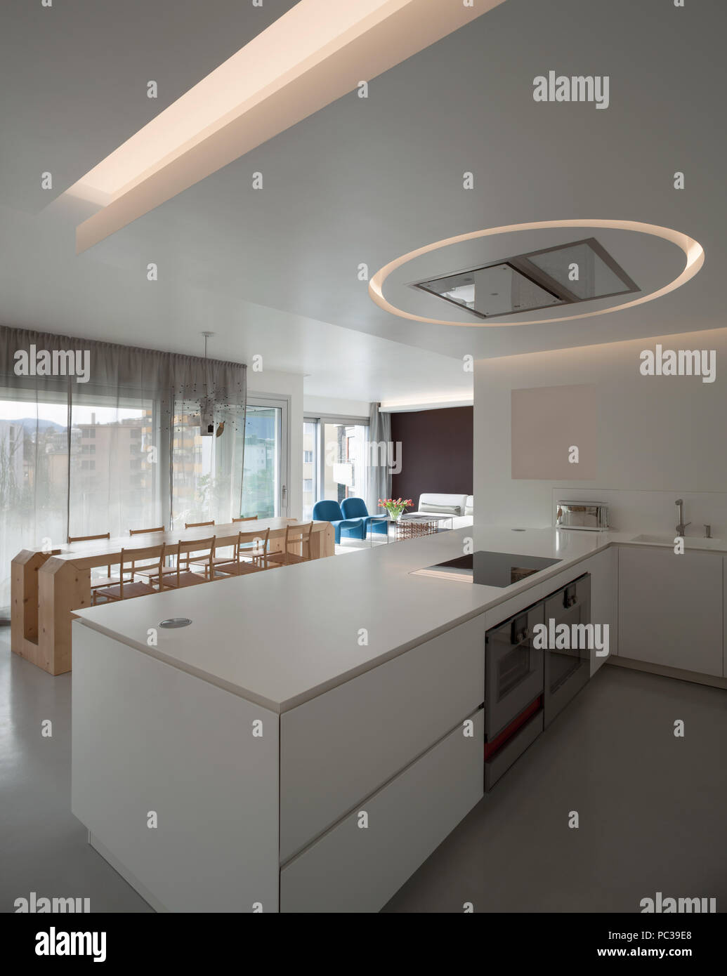 Luxury apartment, modern kitchen and wooden dining table Stock Photo