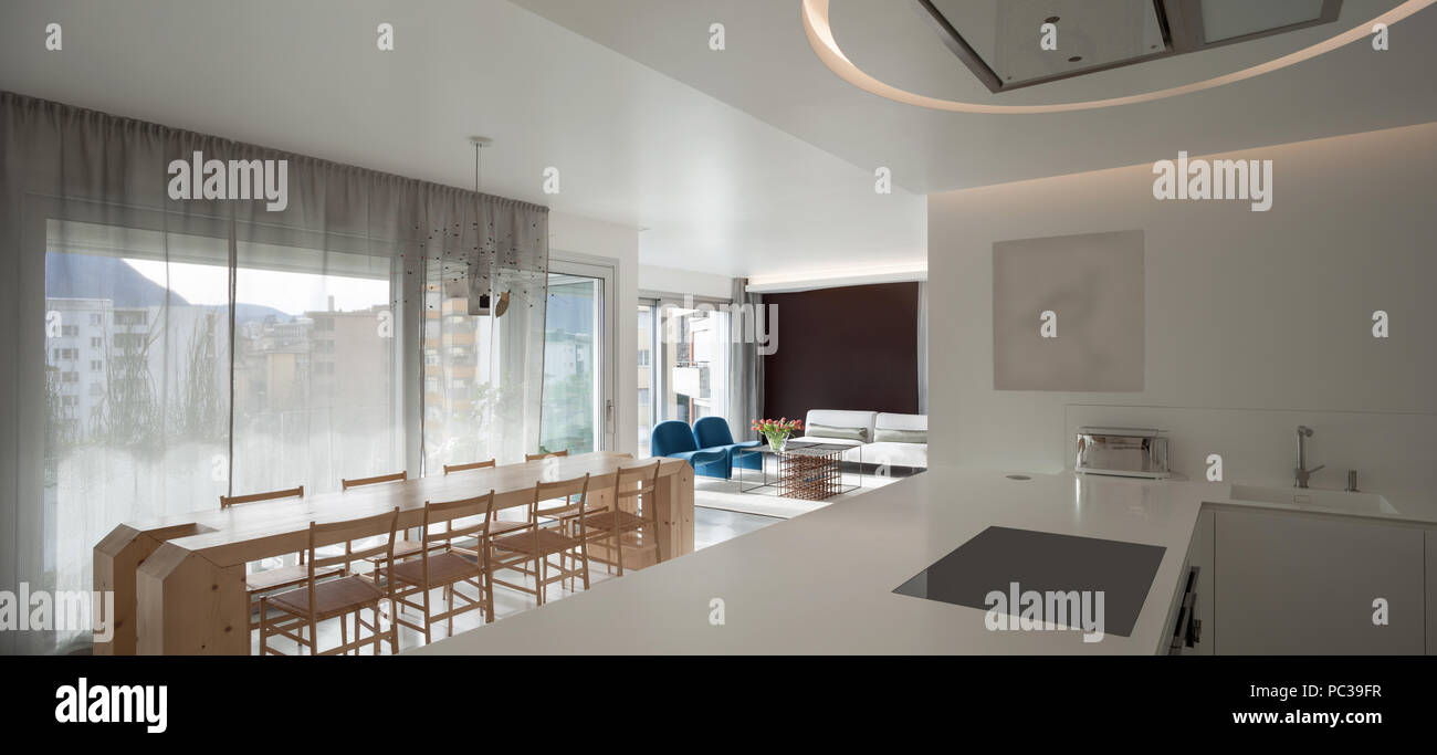 Luxury apartment, modern kitchen and wooden dining table Stock Photo